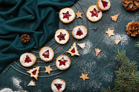 Cooling rack with tasty Linzer cookies on dark background