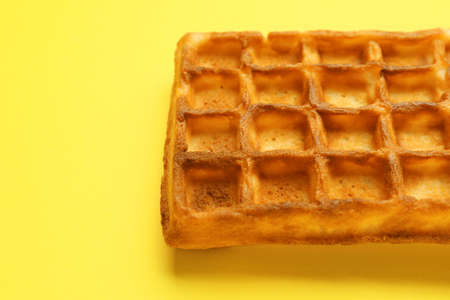 Tasty Belgian waffle on color background, closeup