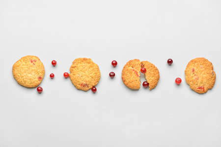 Tasty cranberry cookies and berries on white background