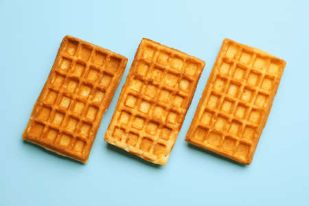 Tasty Belgian waffles on blue backgroundの写真素材