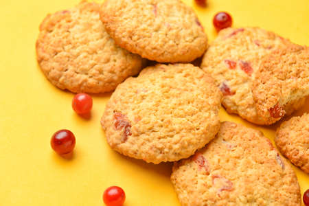 Delicious cranberry cookies and berries on yellow background, closeupの写真素材