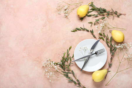 Stylish table setting, plant branches, gypsophila flowers and pears on color backgroundの写真素材