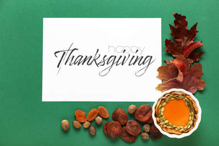 Autumn composition with pumpkin pie and text THANKSGIVING on color backgroundの写真素材
