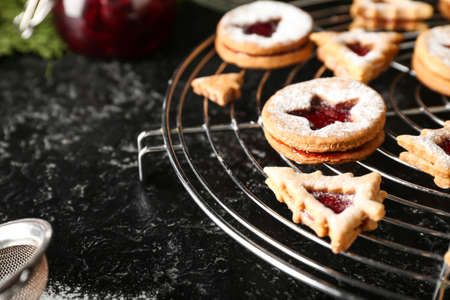 Cooling rack with traditional Linzer cookies on dark background