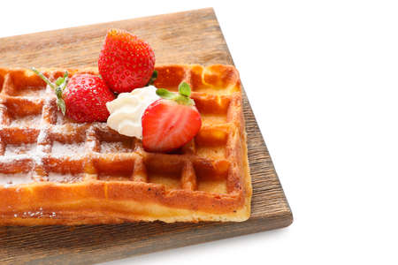 Wooden board of tasty Belgian Waffle with strawberry on white background, closeupの写真素材