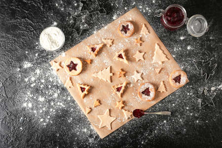 Preparing of tasty Linzer cookies on dark background