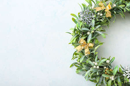 Beautiful mistletoe wreath on light wall