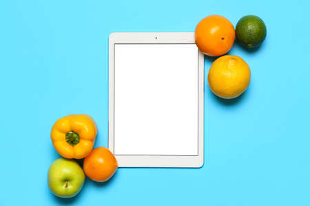Fresh products and tablet computer on blue background. World Vegan Day conceptの写真素材