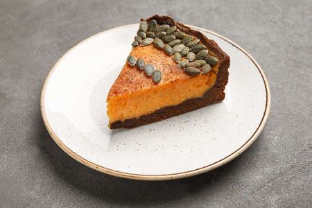 Plate with piece of delicious pumpkin pie on gray backgroundの写真素材