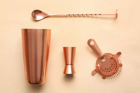 Cobbler shaker, double jigger, strainer and mixing spoon on color backgroundの写真素材