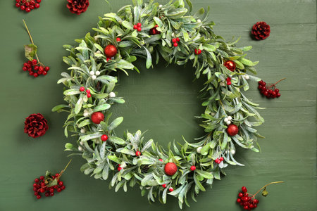 Beautiful mistletoe wreath on green wooden backgroundの写真素材