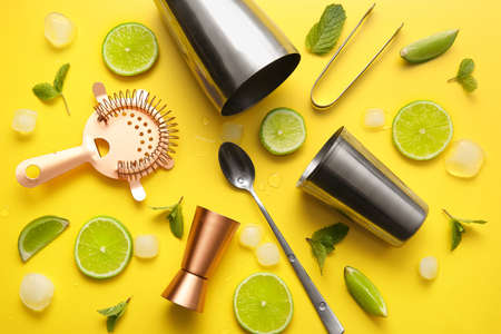 Different bartender tools and cocktail ingredients on yellow background, closeupの写真素材
