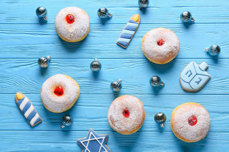 Cookies with sufganiyah donuts for Hanukkah celebration and Christmas decor on color wooden backgroundの写真素材