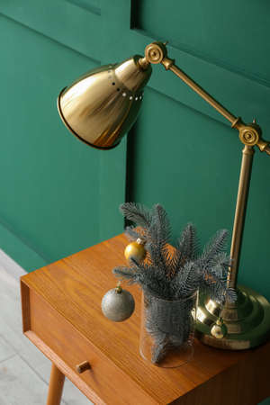 Table with lamp and Christmas decor near color wallの写真素材