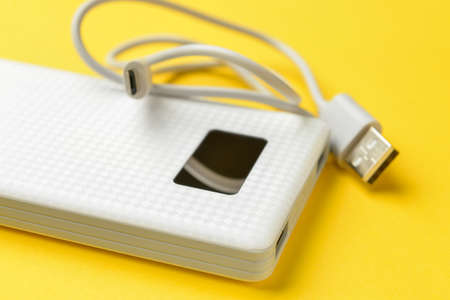 Modern power bank on yellow background, closeupの写真素材