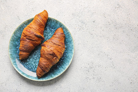 Plate with tasty croissants on light backgroundの写真素材
