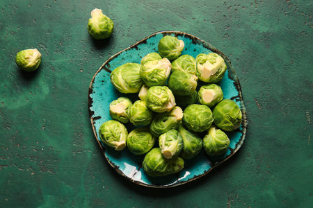 Plate with raw Brussels cabbage on color backgroundの写真素材