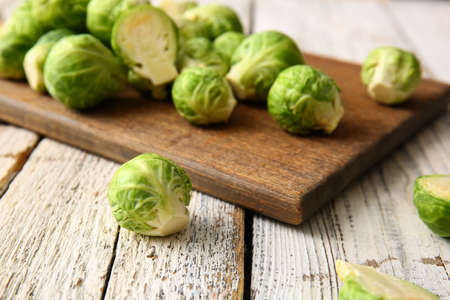 Board with fresh Brussels cabbage on light wooden background, closeupの写真素材