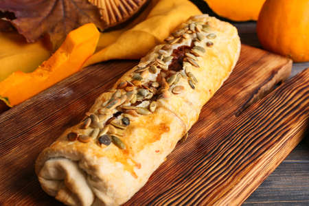 Board with tasty pumpkin strudel on table, closeupの写真素材