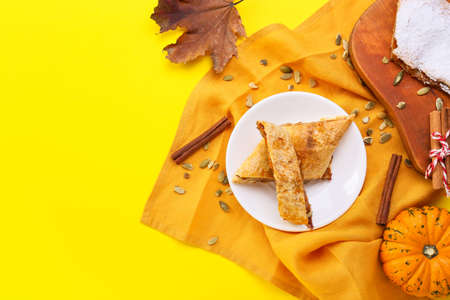 Plate with pieces of tasty pumpkin strudel on yellow backgroundの写真素材