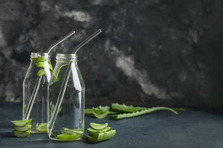 Glass bottles of aloe juice with straws on dark backgroundの写真素材
