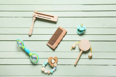Baby hair comb and different accessories on green wooden backgroundの写真素材