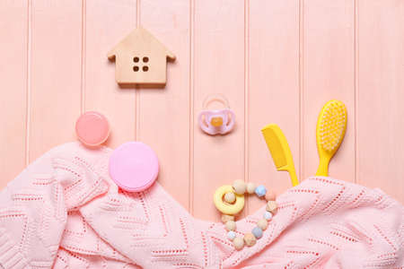 Baby accessories and knitted sweater on pink wooden backgroundの写真素材