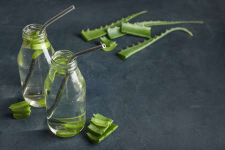 Glass bottles of aloe juice with straws on dark backgroundの写真素材