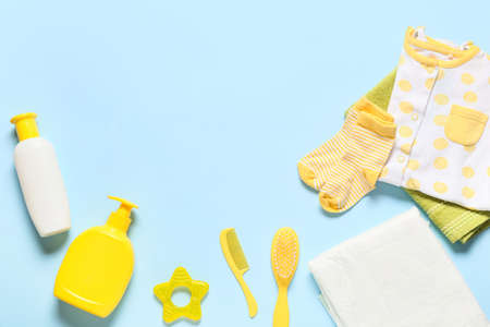 Cute baby clothes and bath accessories on blue backgroundの写真素材