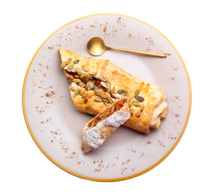 Plate with pieces of delicious pumpkin strudel on white backgroundの写真素材