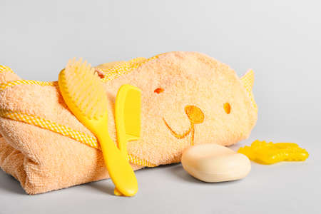 Soft towel for baby, hair brushes and bar of soap on light backgroundの写真素材