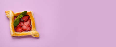 Sweet strawberry puff pastry on lilac background with space for textの写真素材