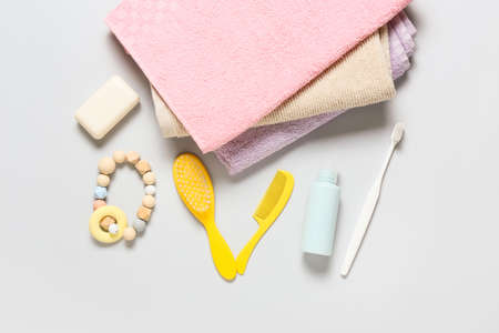 Stack of soft towels and different bath accessories for baby on light backgroundの写真素材