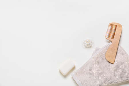 Wooden hair comb, towel, bar soap and pacifier on white background, closeupの写真素材