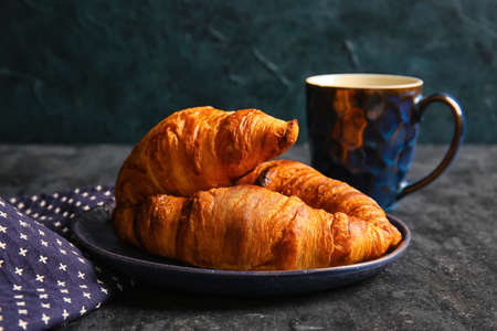 Plate with delicious croissants on black backgroundの写真素材