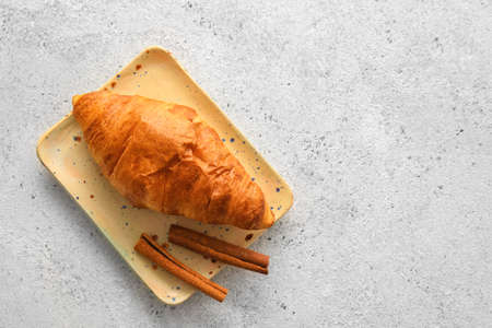 Plate with delicious croissants on white background