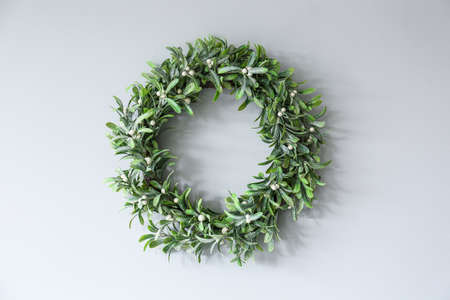 Beautiful mistletoe wreath hanging light on wall in roomの写真素材