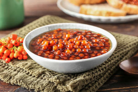Bowl with sweet rowan jam on wooden background, closeupの写真素材