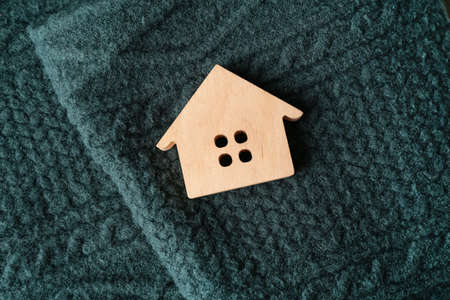House figure on warm green scarf. winter conceptの写真素材