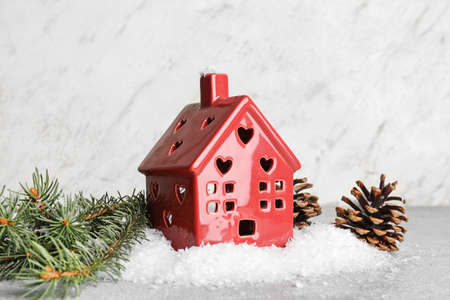 House figure with fir branches and cones on light background. winter conceptの写真素材