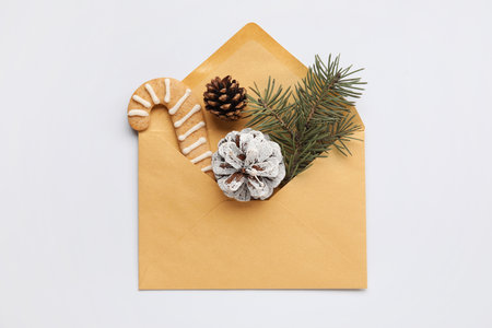Envelope with fir tree branch, pine cones and cookie on white backgroundの写真素材