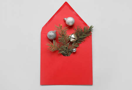 Envelope with fir tree branch and balls on light background
