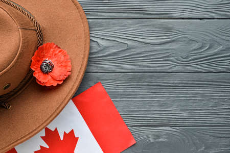 Poppy flower with hat and flag of Canada on wooden background. Remembrance Dayの写真素材