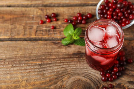 Glass with healthy cranberry juice on wooden backgroundの写真素材