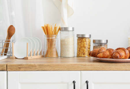 Tasty food on wooden counter near light wall