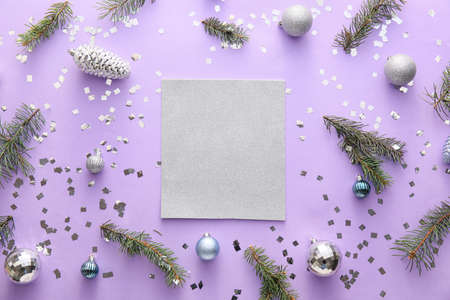 Composition with blank card, fir branches and Christmas decorations on lilac backgroundの写真素材