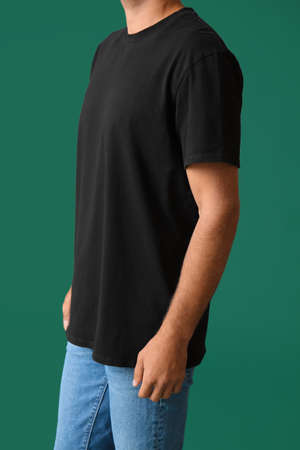 Handsome young man in stylish t-shirt on color backgroundの写真素材