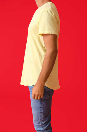 Handsome young man in stylish t-shirt on color background