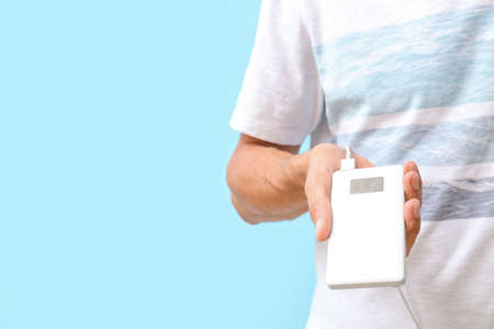 Young man with phone on color background, closeup