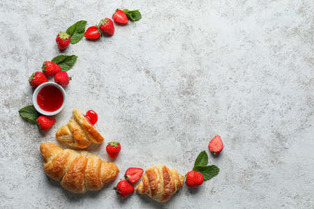 Delicious croissants with strawberry jam on light backgroundの写真素材
